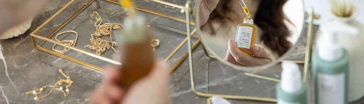 A person applying true dew face oil 