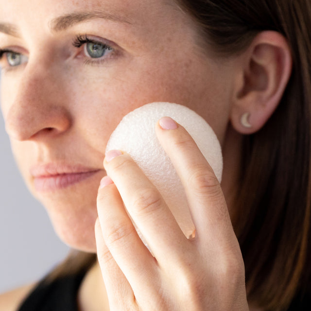 A person lightly exfoliating their skin with the Konjac Kare yam extract hydrating vegetable fibre sponge 